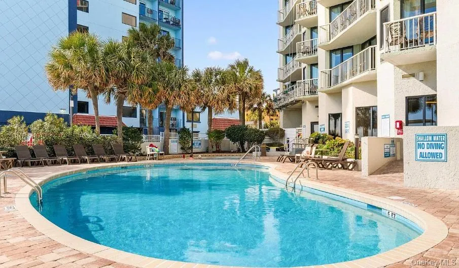 Community pool with a patio area Community pool with a patio area