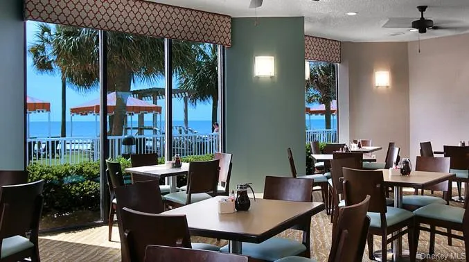 Dining room with ceiling fan, a textured ceiling, and a water view Dining room with ceiling fan, a textured ceiling, and a water view