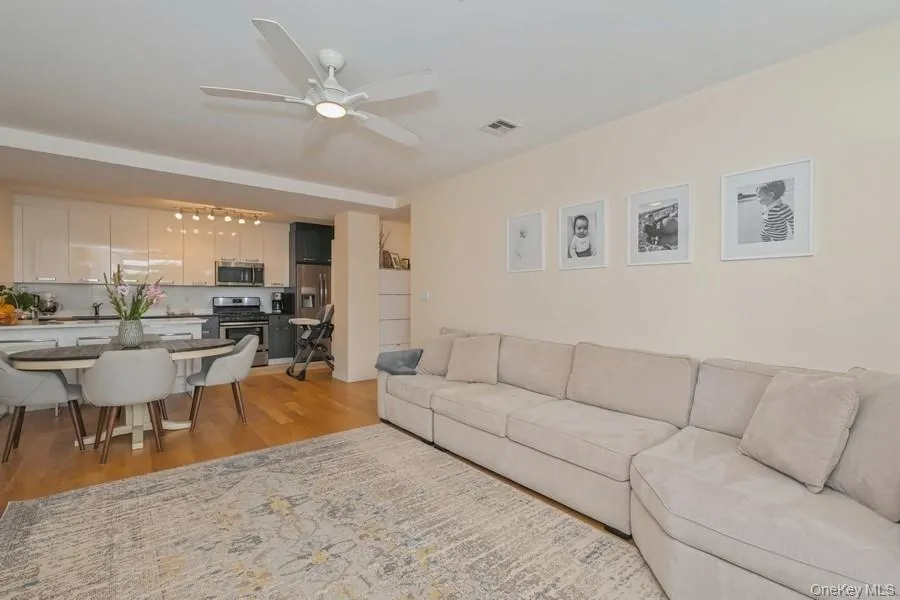 Living area featuring light wood finished floors and a ceiling fan Living area featuring light wood finished floors and a ceiling fan