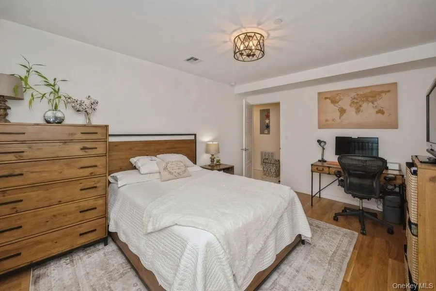 Bedroom with wood finished floors and an office area Bedroom with wood finished floors and an office area