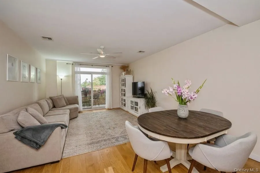 Living room featuring light wood-type flooring and a ceiling fan Living room featuring light wood-type flooring and a ceiling fan