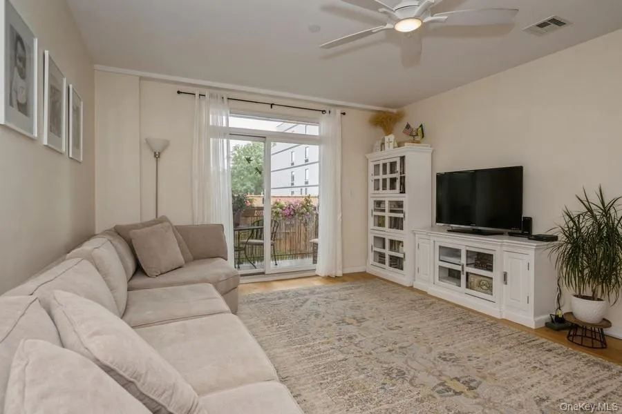 Living area featuring wood finished floors and ceiling fan Living area featuring wood finished floors and ceiling fan