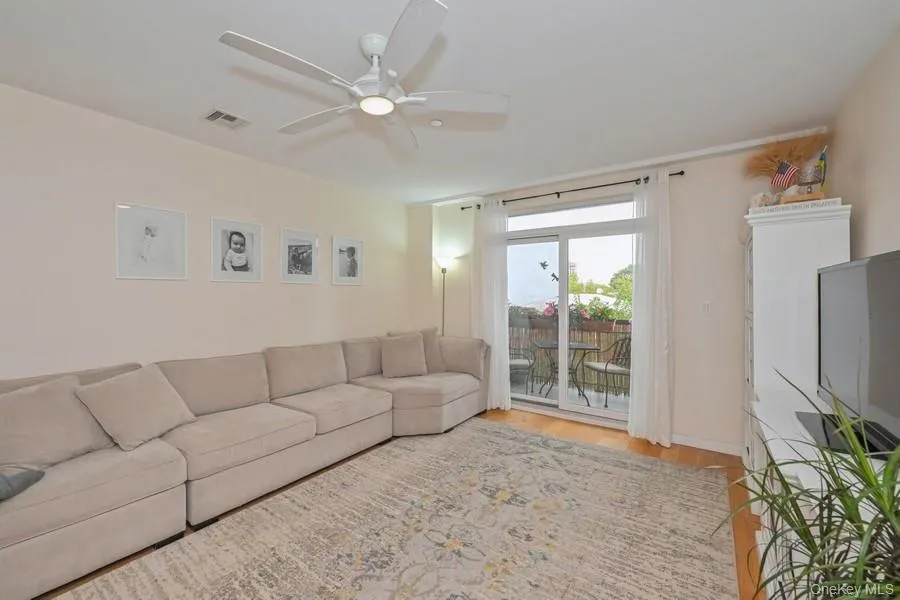 Living area featuring light wood-style floors and a ceiling fan Living area featuring light wood-style floors and a ceiling fan