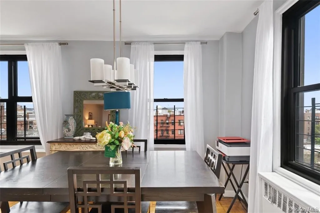 Dining room featuring radiator, healthy amount of natural light, and light wood-style flooring Dining room featuring radiator, healthy amount of natural light, and light wood-style flooring