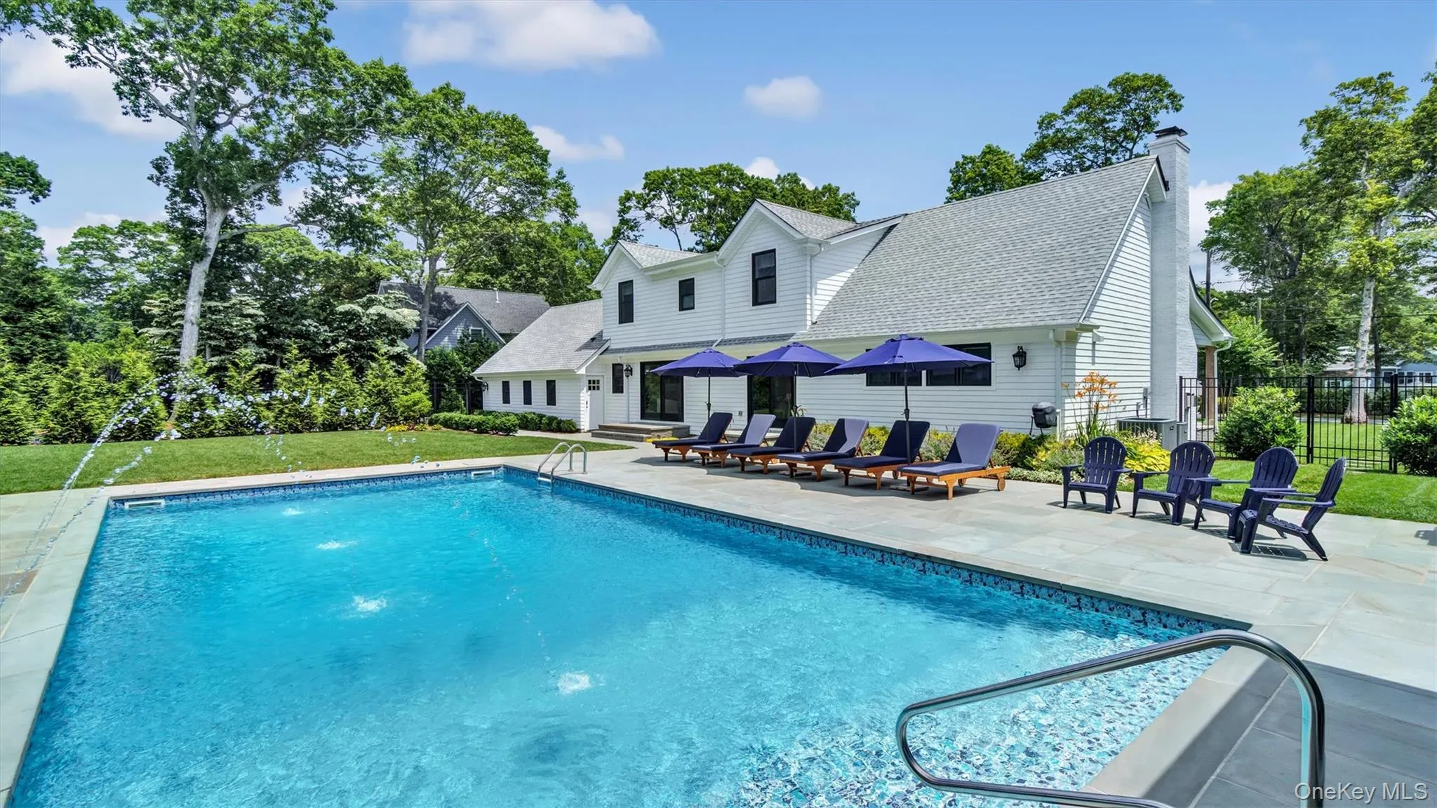 View of swimming pool featuring a patio and view of scattered trees View of swimming pool featuring a patio and view of scattered trees