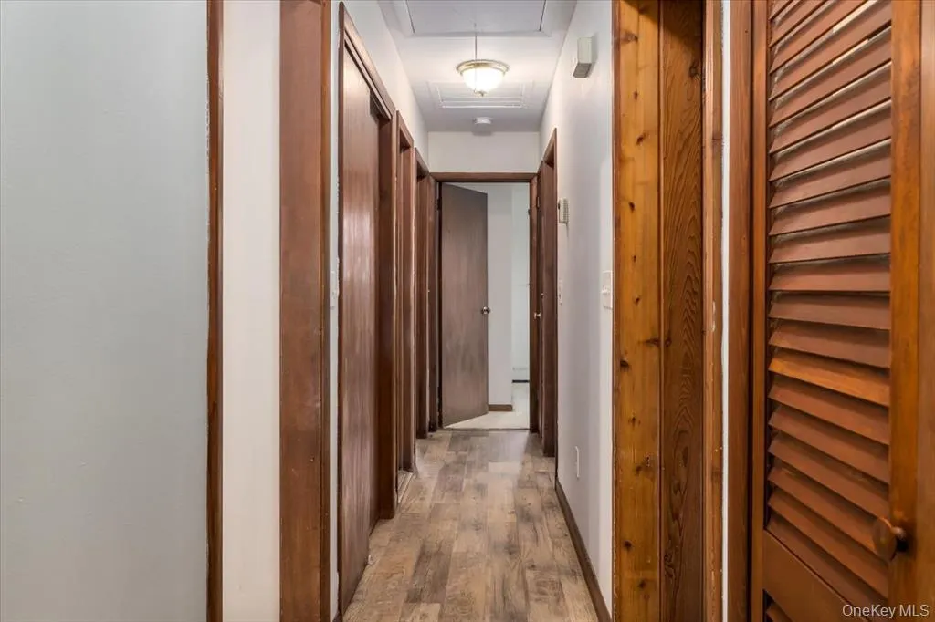 Hall featuring light wood-style floors and baseboards Hall featuring light wood-style floors and baseboards