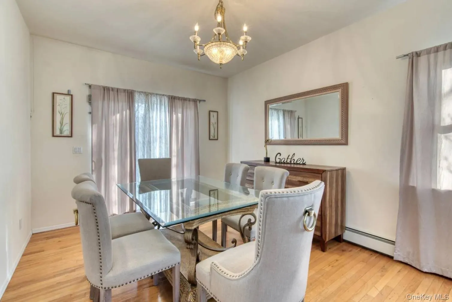 Dining area featuring light wood-type flooring, baseboard heating, and a chandelier Dining area featuring light wood-type flooring, baseboard heating, and a chandelier