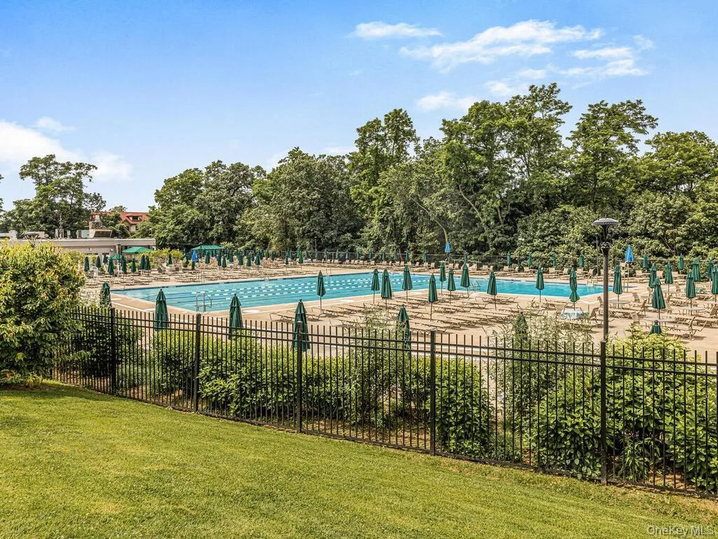 Community pool featuring view of scattered trees Community pool featuring view of scattered trees