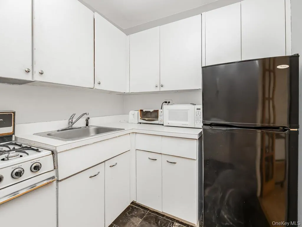 Kitchen with white appliances, white cabinets, and light countertops Kitchen with white appliances, white cabinets, and light countertops