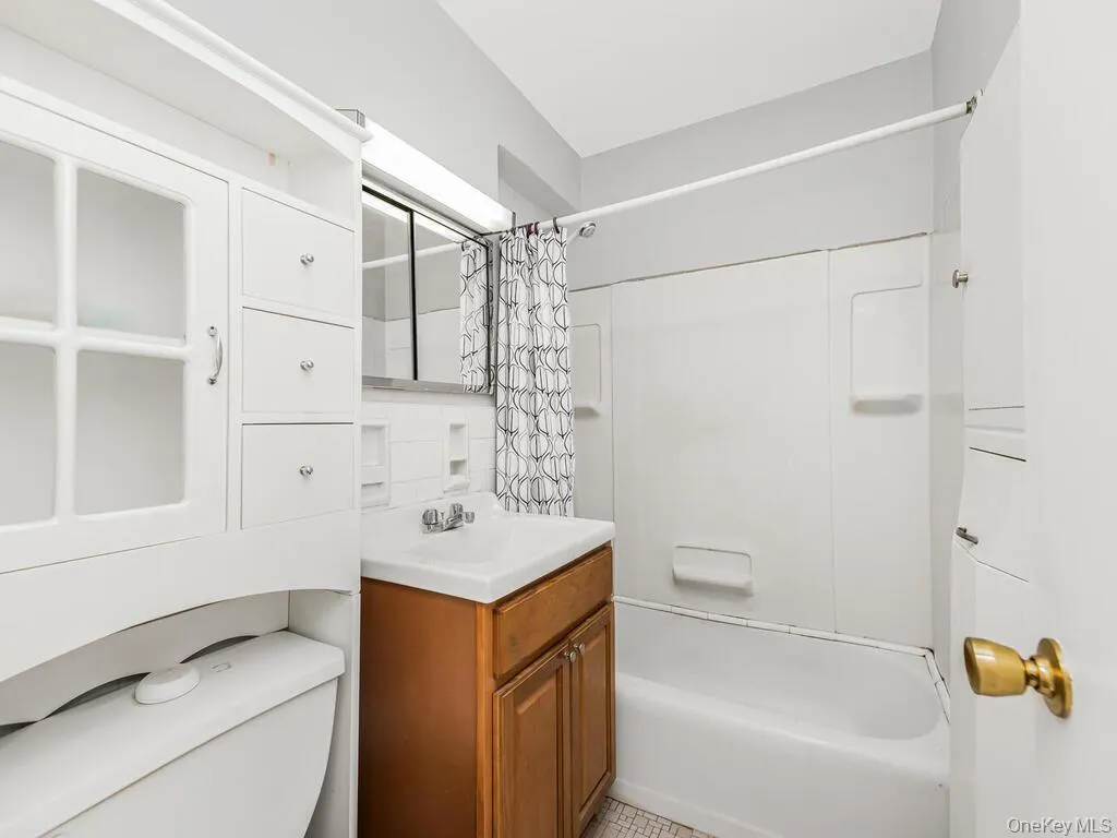 Full bathroom featuring shower / bath combination with curtain and vanity Full bathroom featuring shower / bath combination with curtain and vanity