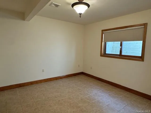 Spare room with baseboards and beam ceiling Spare room with baseboards and beam ceiling