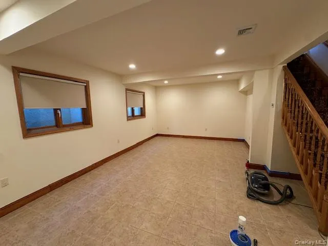 Finished below grade area with stairway and recessed lighting Finished below grade area with stairway and recessed lighting