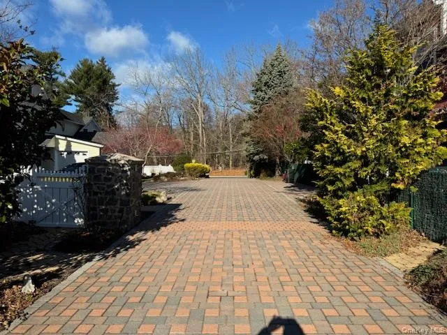 View of brick / pavers driveway with a gate and view of wooded area View of brick / pavers driveway with a gate and view of wooded area
