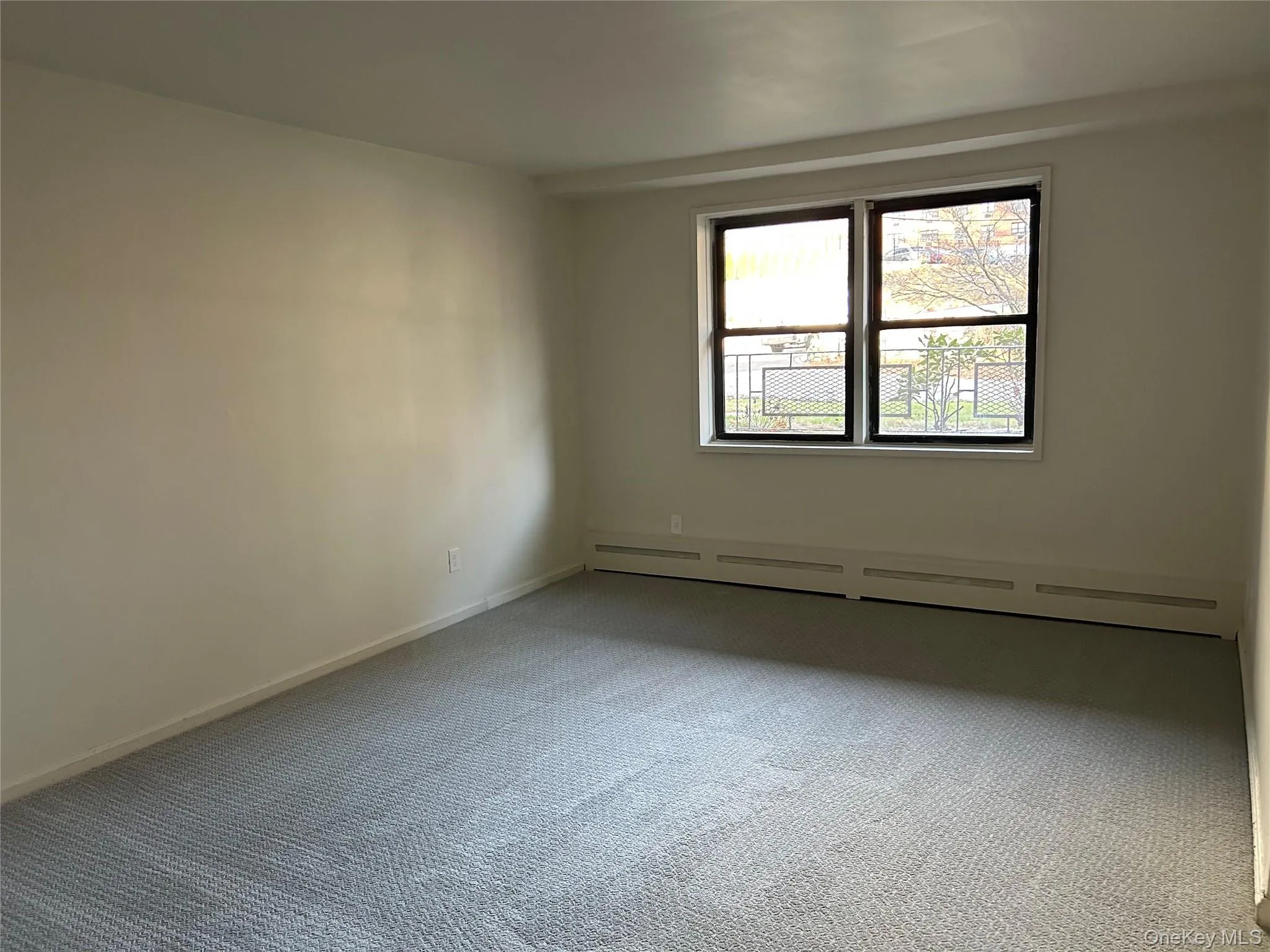 Unfurnished room featuring a baseboard heating unit and carpet Unfurnished room featuring a baseboard heating unit and carpet