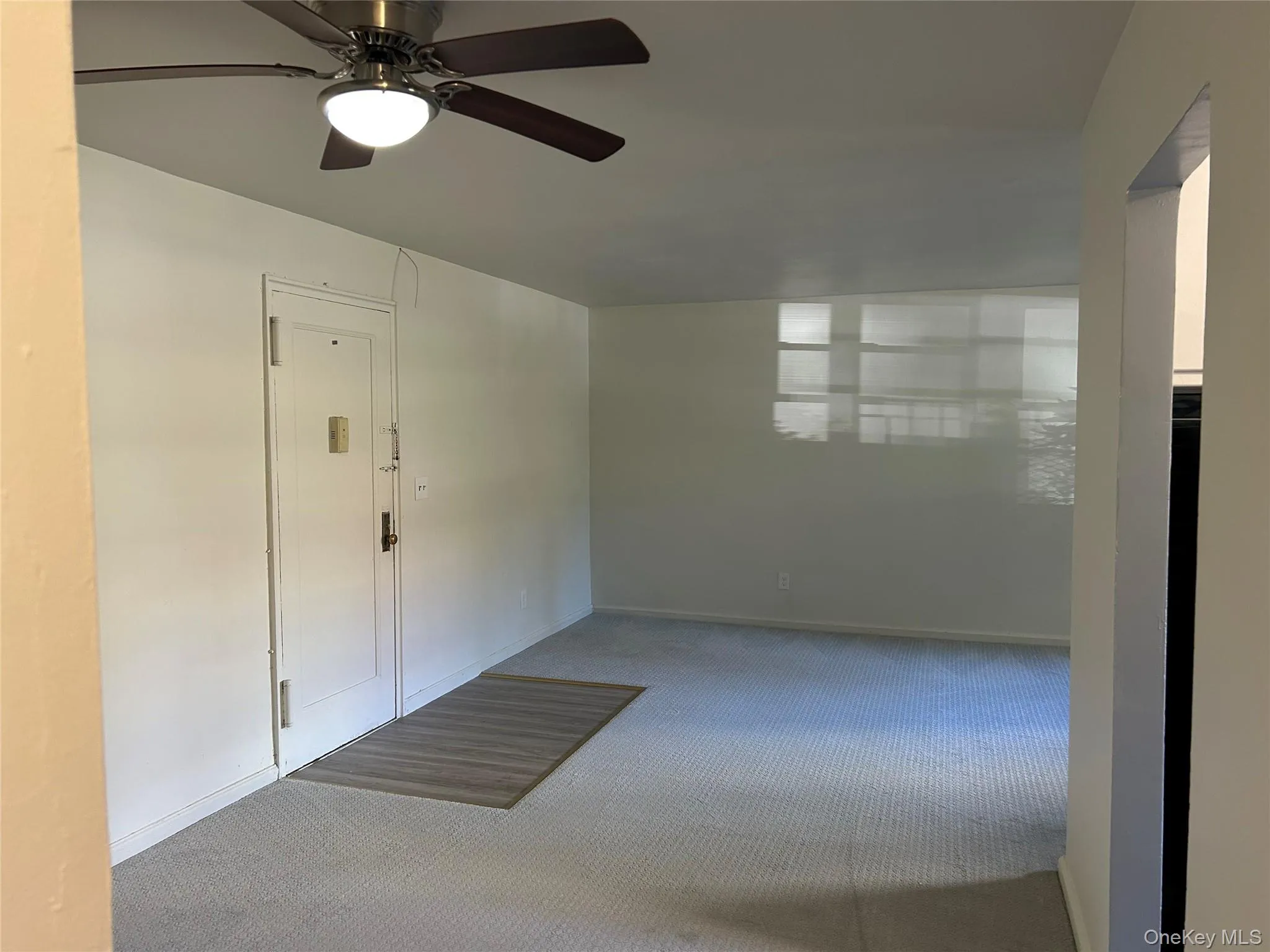 Carpeted foyer with baseboards and a ceiling fan Carpeted foyer with baseboards and a ceiling fan