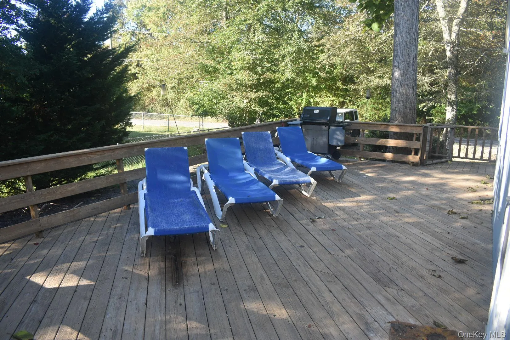 Wooden terrace featuring a grill Wooden terrace featuring a grill