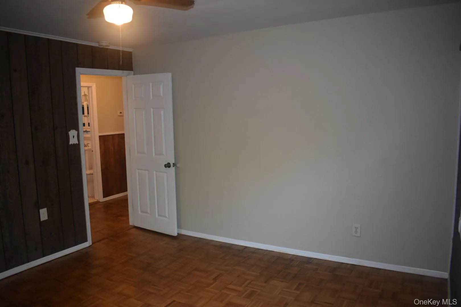 Empty room featuring a ceiling fan and wooden walls Empty room featuring a ceiling fan and wooden walls