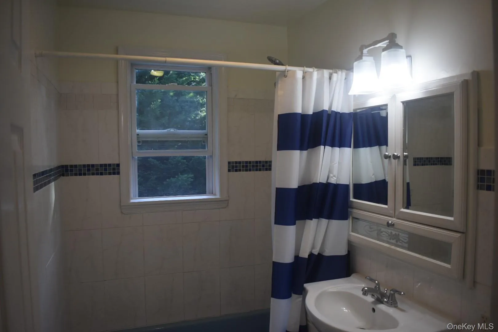 Bathroom featuring a sink and shower / bathtub combination with curtain Bathroom featuring a sink and shower / bathtub combination with curtain