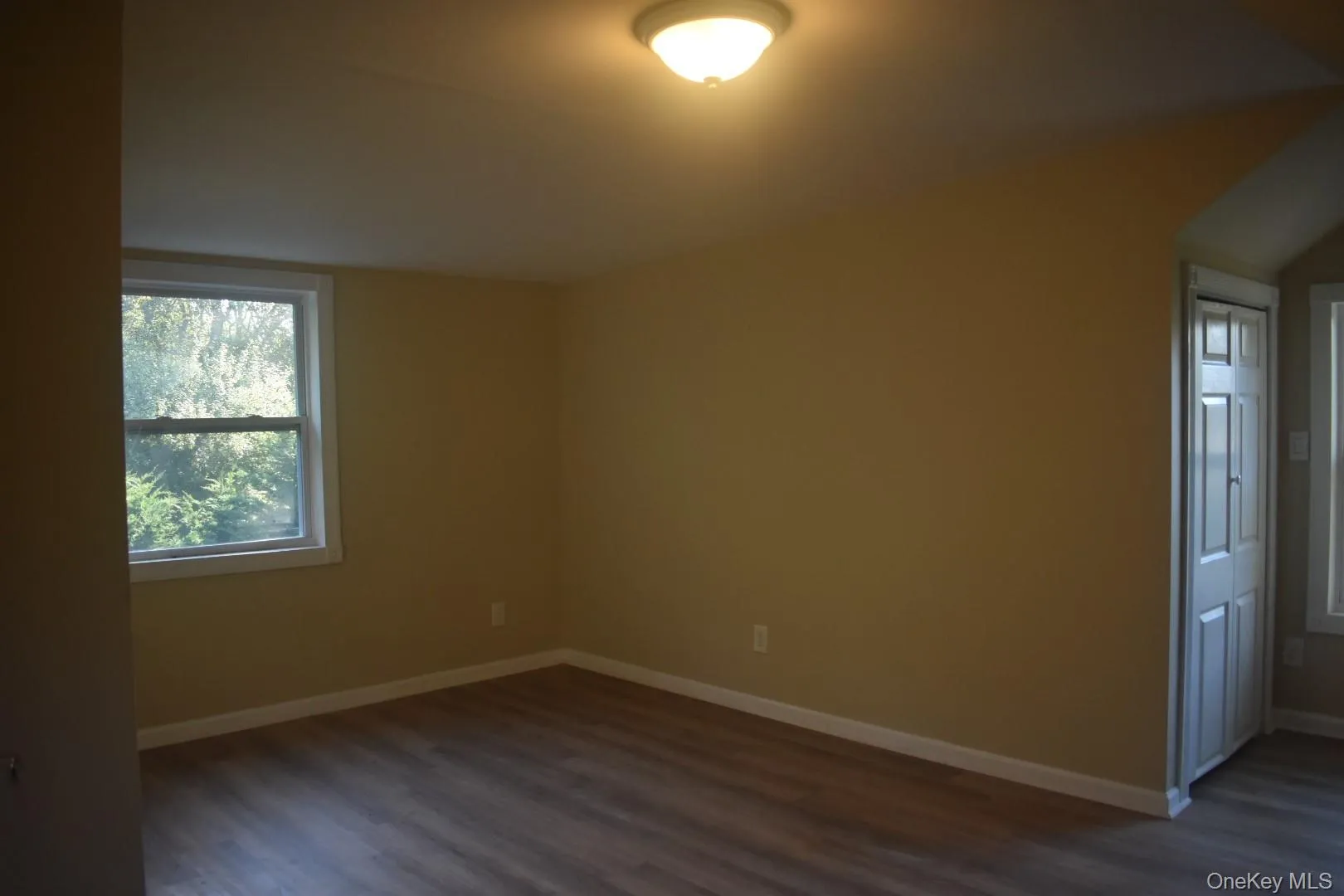 Spare room featuring baseboards and dark wood finished floors Spare room featuring baseboards and dark wood finished floors