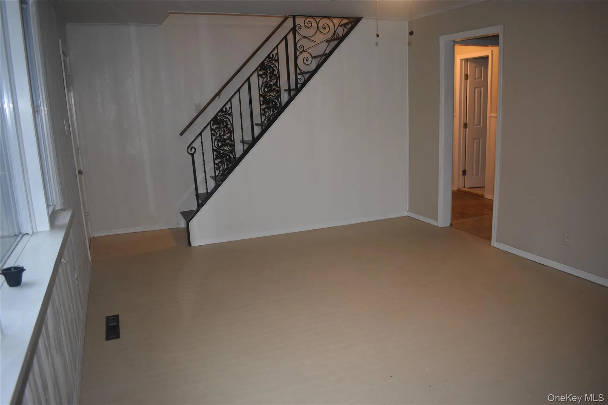 Unfurnished living room featuring baseboards and stairway Unfurnished living room featuring baseboards and stairway