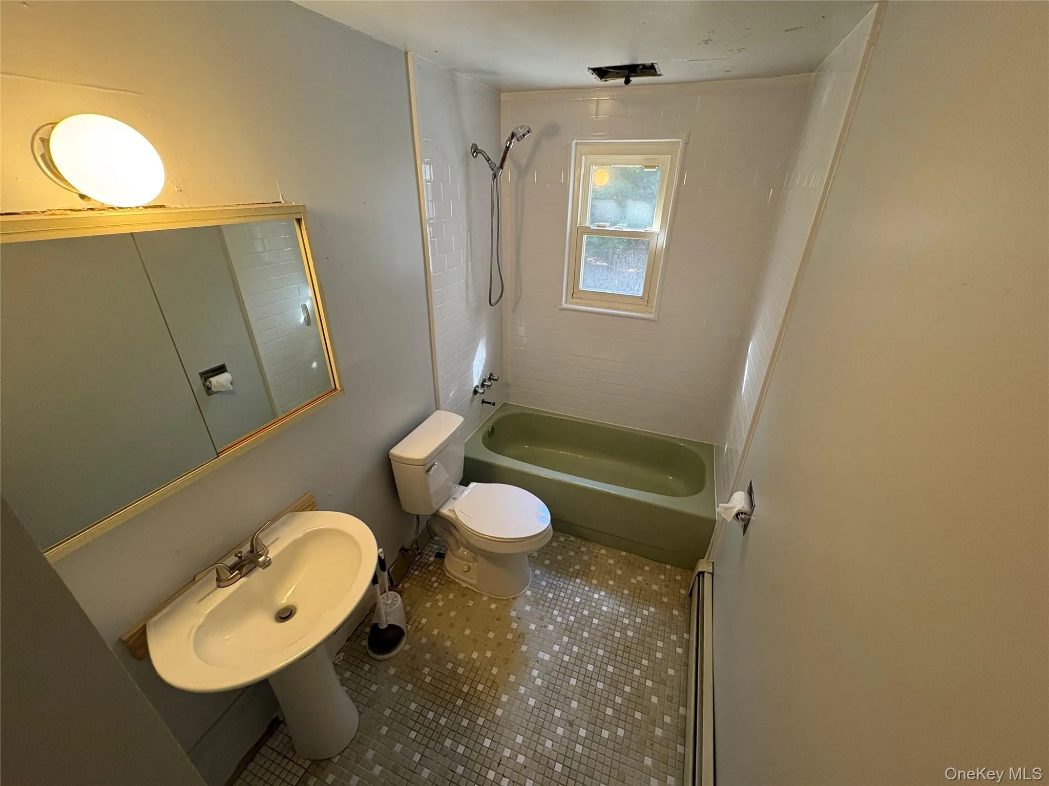 Bathroom featuring shower / bath combination, a baseboard heating unit, and tile patterned flooring Bathroom featuring shower / bath combination, a baseboard heating unit, and tile patterned flooring