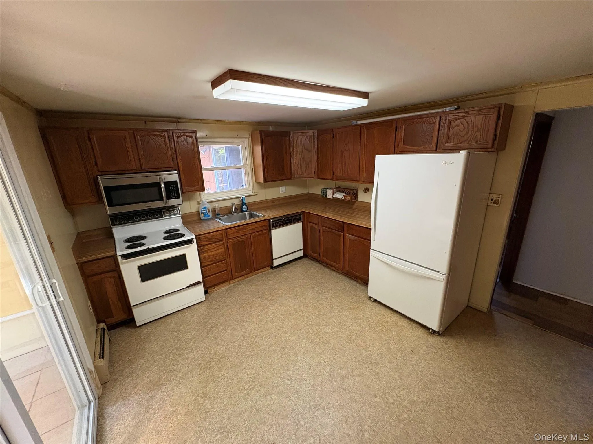 Kitchen featuring white appliances, light countertops, and light flooring Kitchen featuring white appliances, light countertops, and light flooring