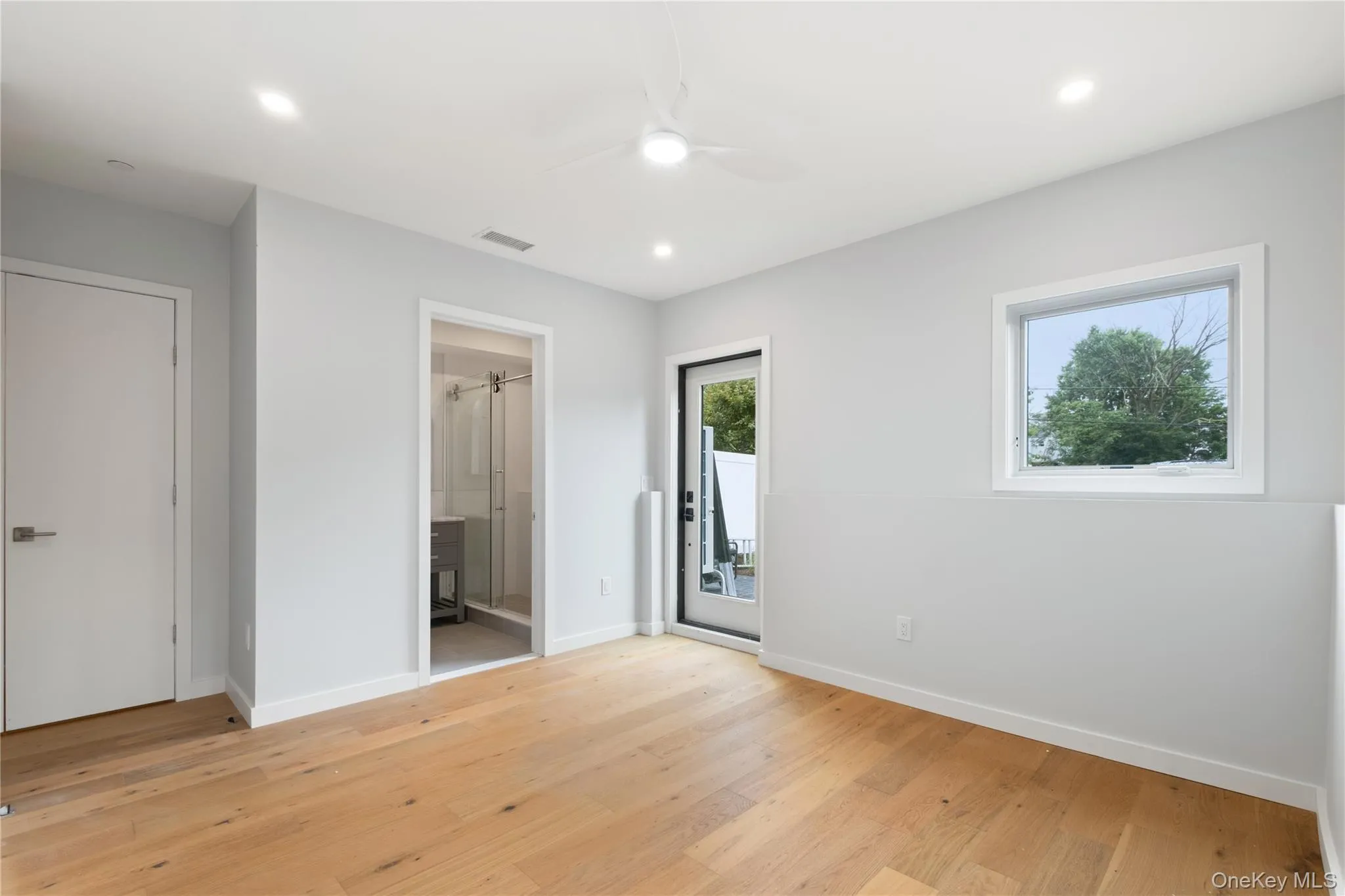 Unfurnished bedroom with light wood-style floors, recessed lighting, a ceiling fan, connected bathroom, and access to exterior Unfurnished bedroom with light wood-style floors, recessed lighting, a ceiling fan, connected bathroom, and access to exterior