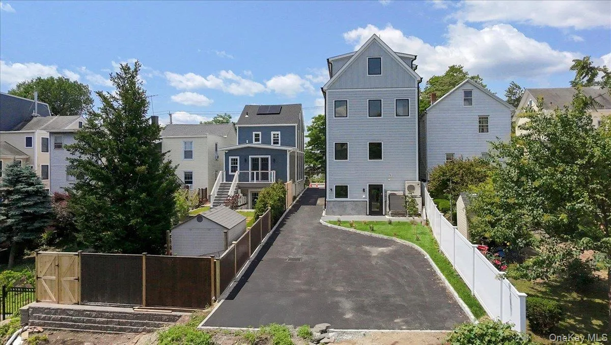 View of front facade featuring board and batten siding, a residential view, a fenced backyard, and driveway View of front facade featuring board and batten siding, a residential view, a fenced backyard, and driveway