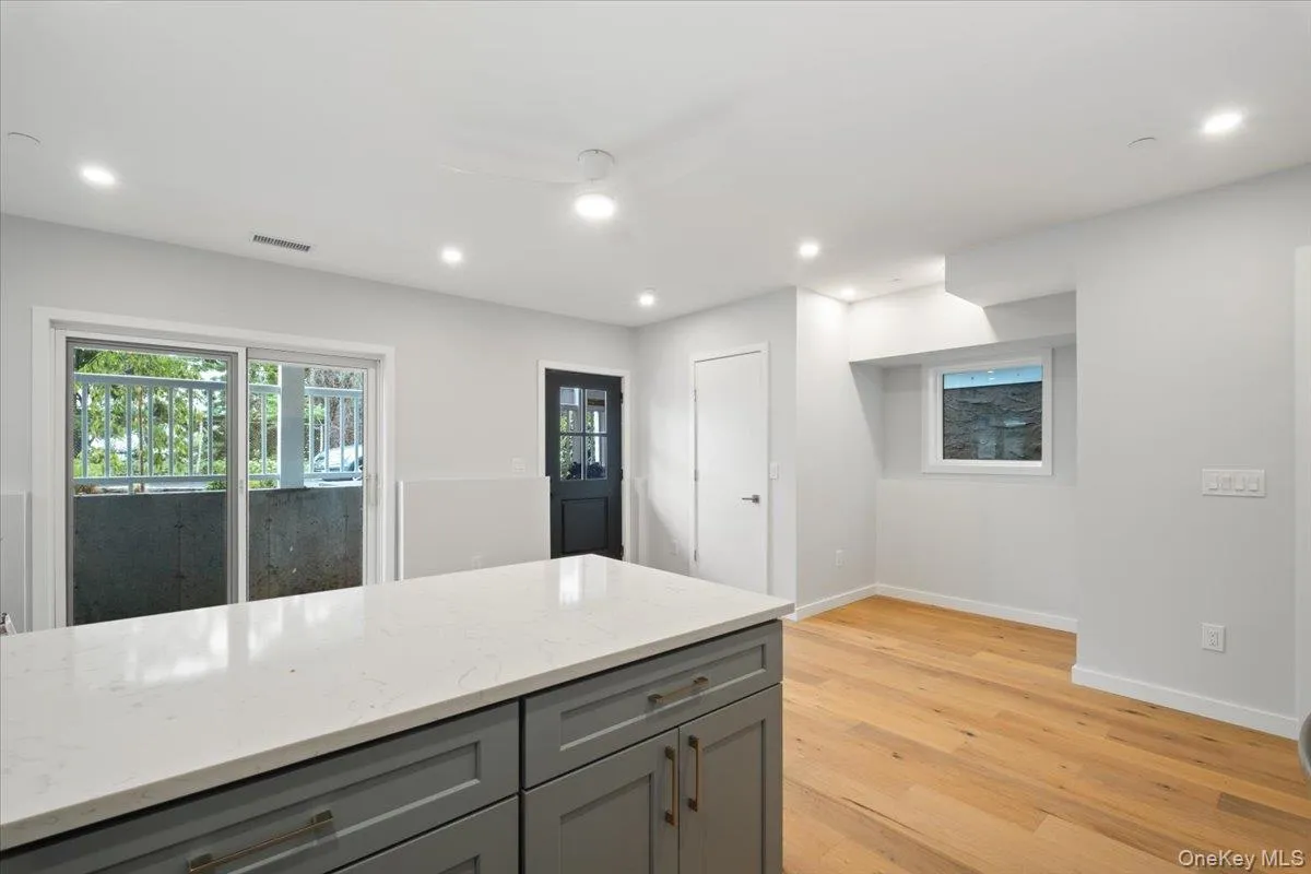 Kitchen featuring gray cabinetry, light wood-style flooring, recessed lighting, light stone counters, and ceiling fan Kitchen featuring gray cabinetry, light wood-style flooring, recessed lighting, light stone counters, and ceiling fan