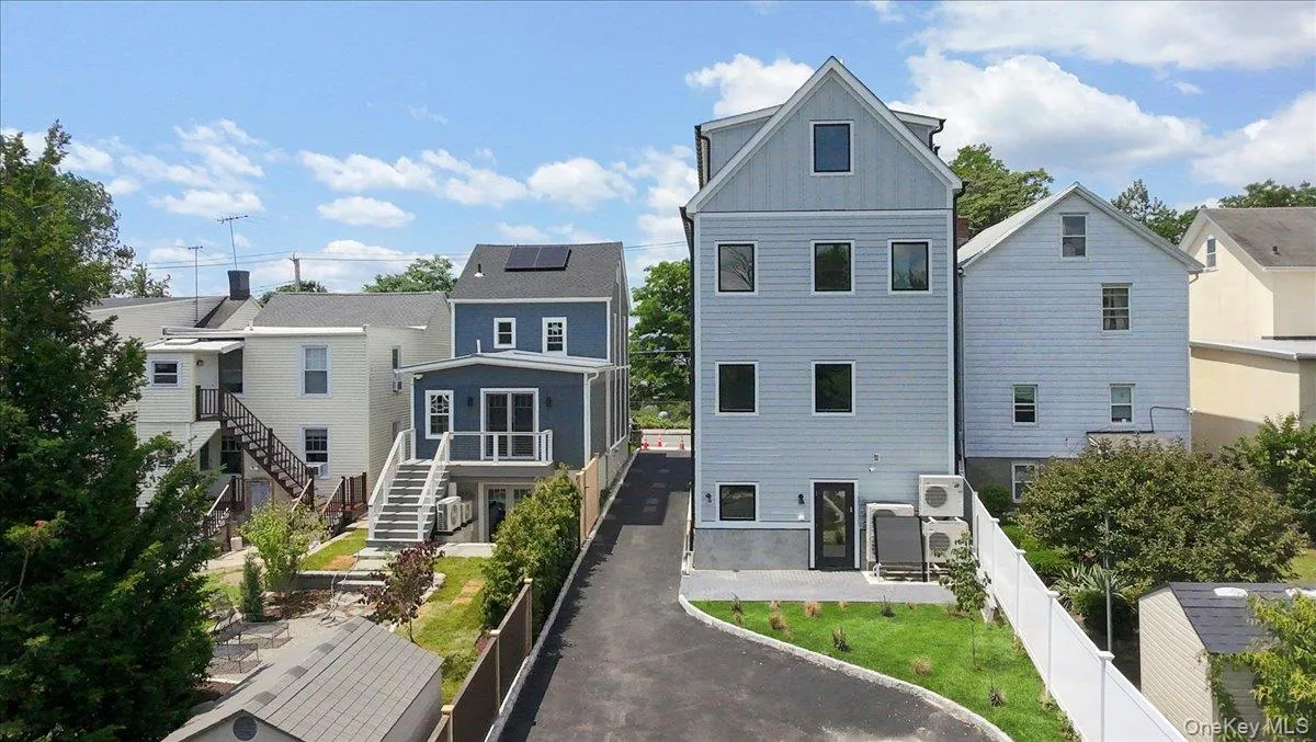 Back of house featuring a fenced backyard, asphalt driveway, board and batten siding, stairway, and a residential view Back of house featuring a fenced backyard, asphalt driveway, board and batten siding, stairway, and a residential view