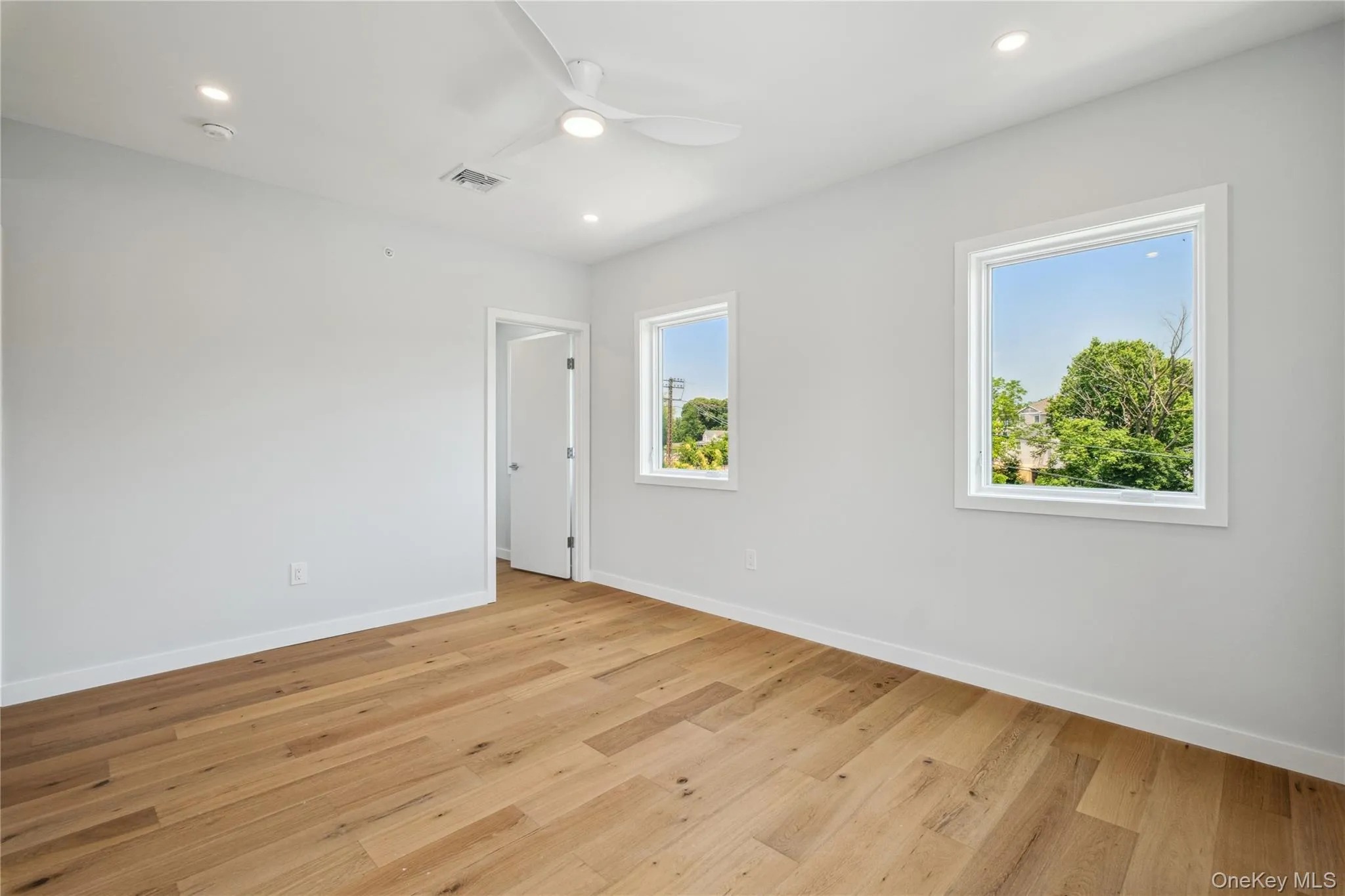 Unfurnished room featuring ceiling fan, light wood finished floors, recessed lighting, and a smoke detector Unfurnished room featuring ceiling fan, light wood finished floors, recessed lighting, and a smoke detector