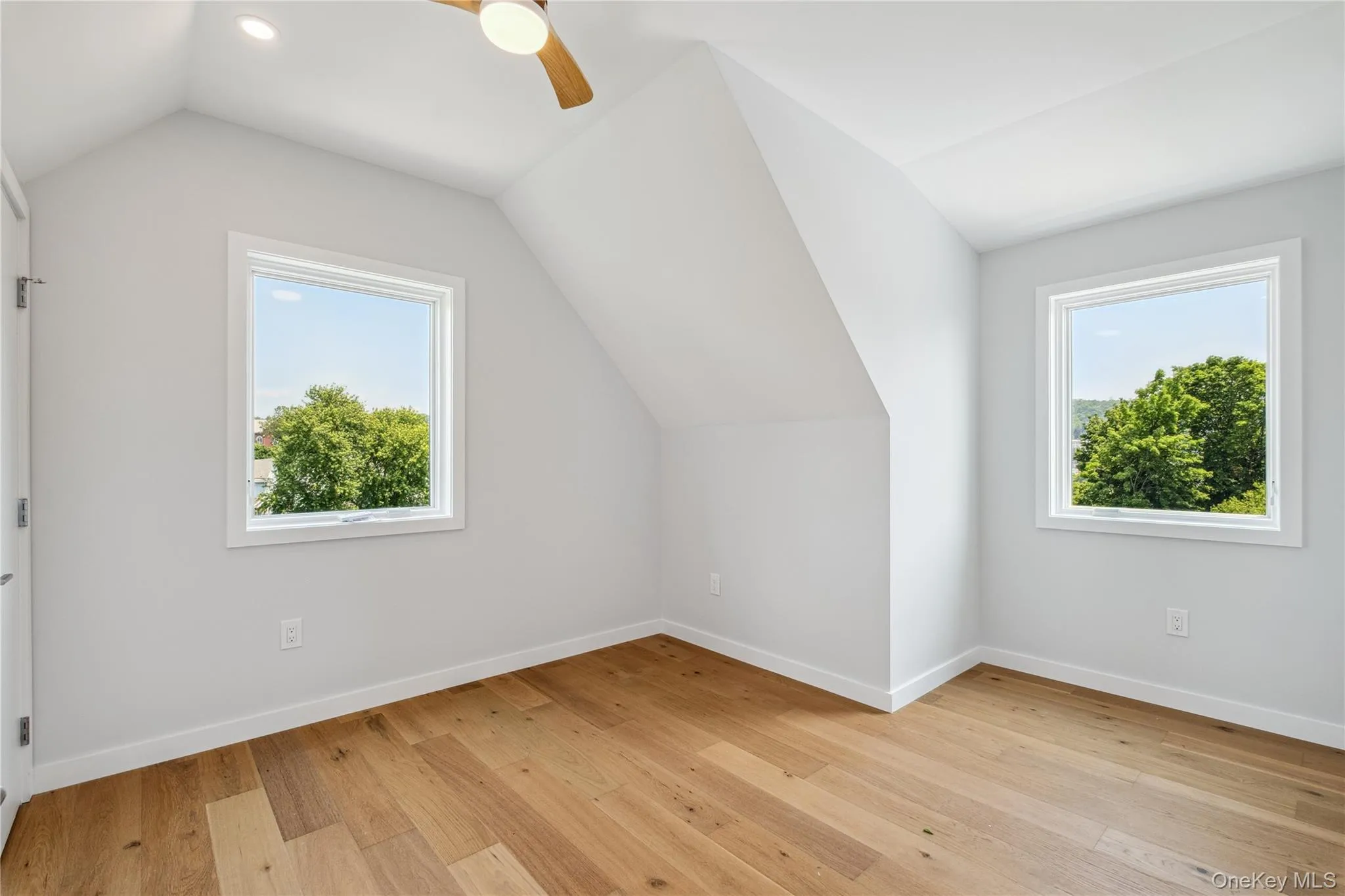 Additional living space featuring vaulted ceiling, light wood-type flooring, and ceiling fan Additional living space featuring vaulted ceiling, light wood-type flooring, and ceiling fan
