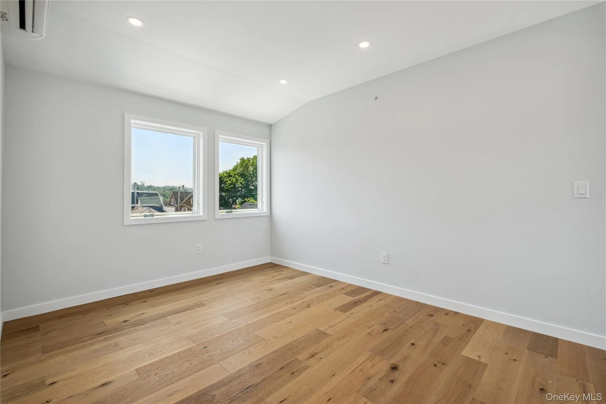 Empty room featuring light wood finished floors, recessed lighting, and lofted ceiling Empty room featuring light wood finished floors, recessed lighting, and lofted ceiling