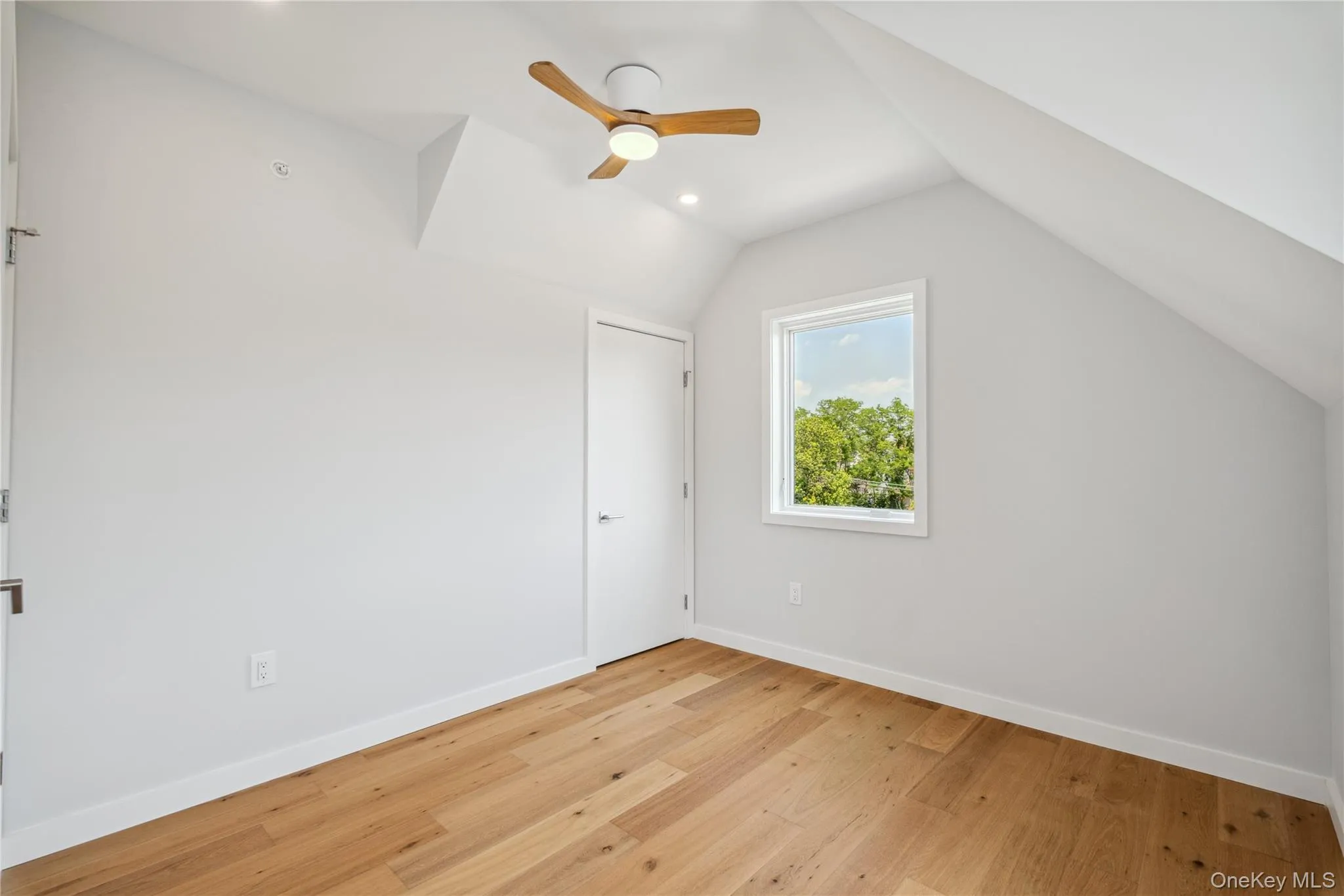 Unfurnished bedroom featuring light wood finished floors, lofted ceiling, and a ceiling fan Unfurnished bedroom featuring light wood finished floors, lofted ceiling, and a ceiling fan