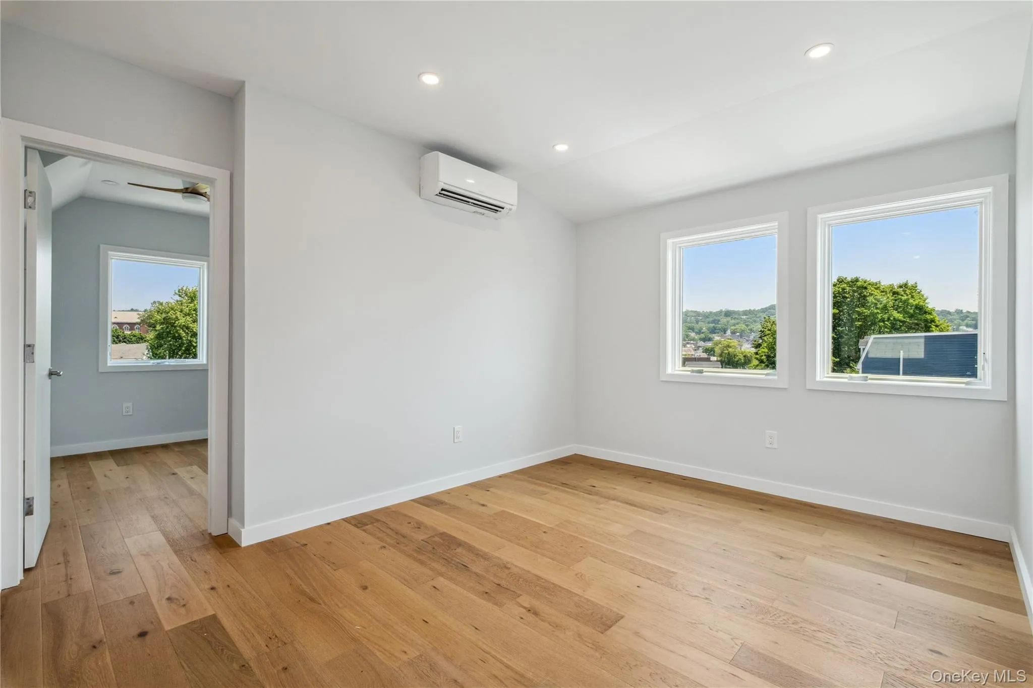 Empty room featuring a wall mounted AC, light wood-type flooring, recessed lighting, and ceiling fan Empty room featuring a wall mounted AC, light wood-type flooring, recessed lighting, and ceiling fan