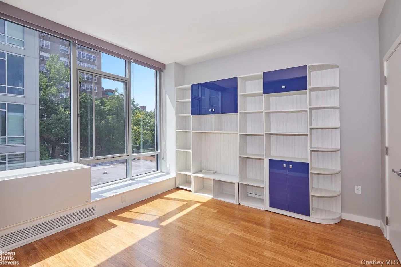 Unfurnished living room with light wood-type flooring and baseboards Unfurnished living room with light wood-type flooring and baseboards