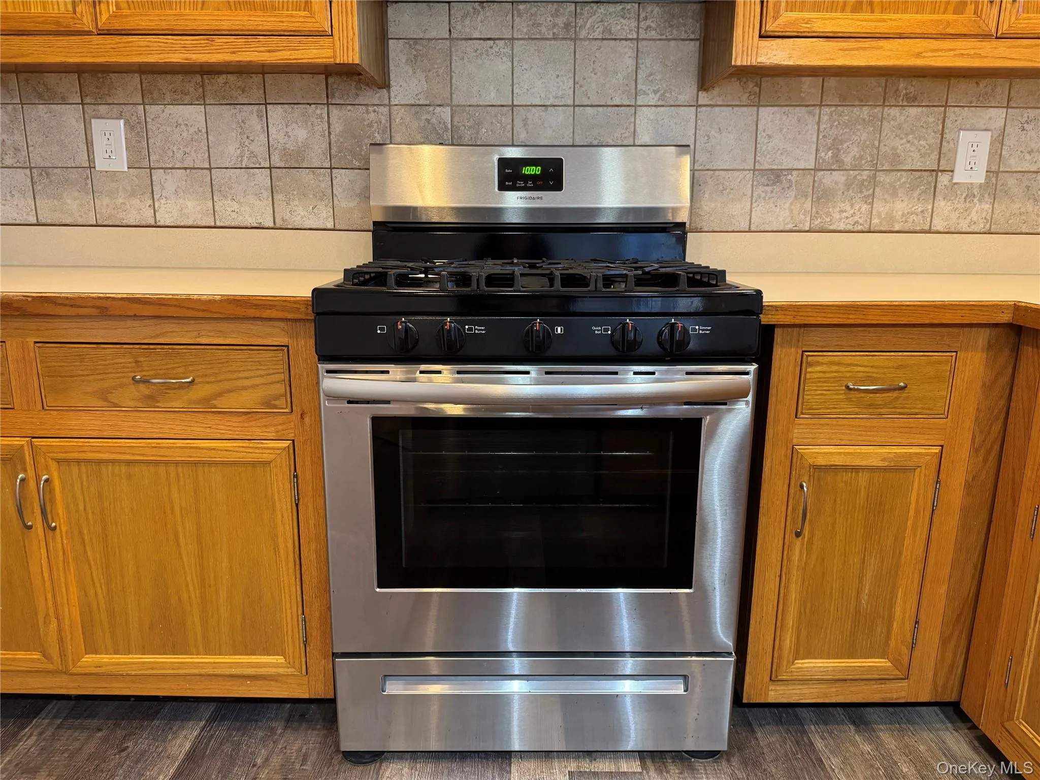 Kitchen featuring dark hardwood / wood-style floors, stainless steel range with gas cooktop, and tasteful backsplash Kitchen featuring dark hardwood / wood-style floors, stainless steel range with gas cooktop, and tasteful backsplash