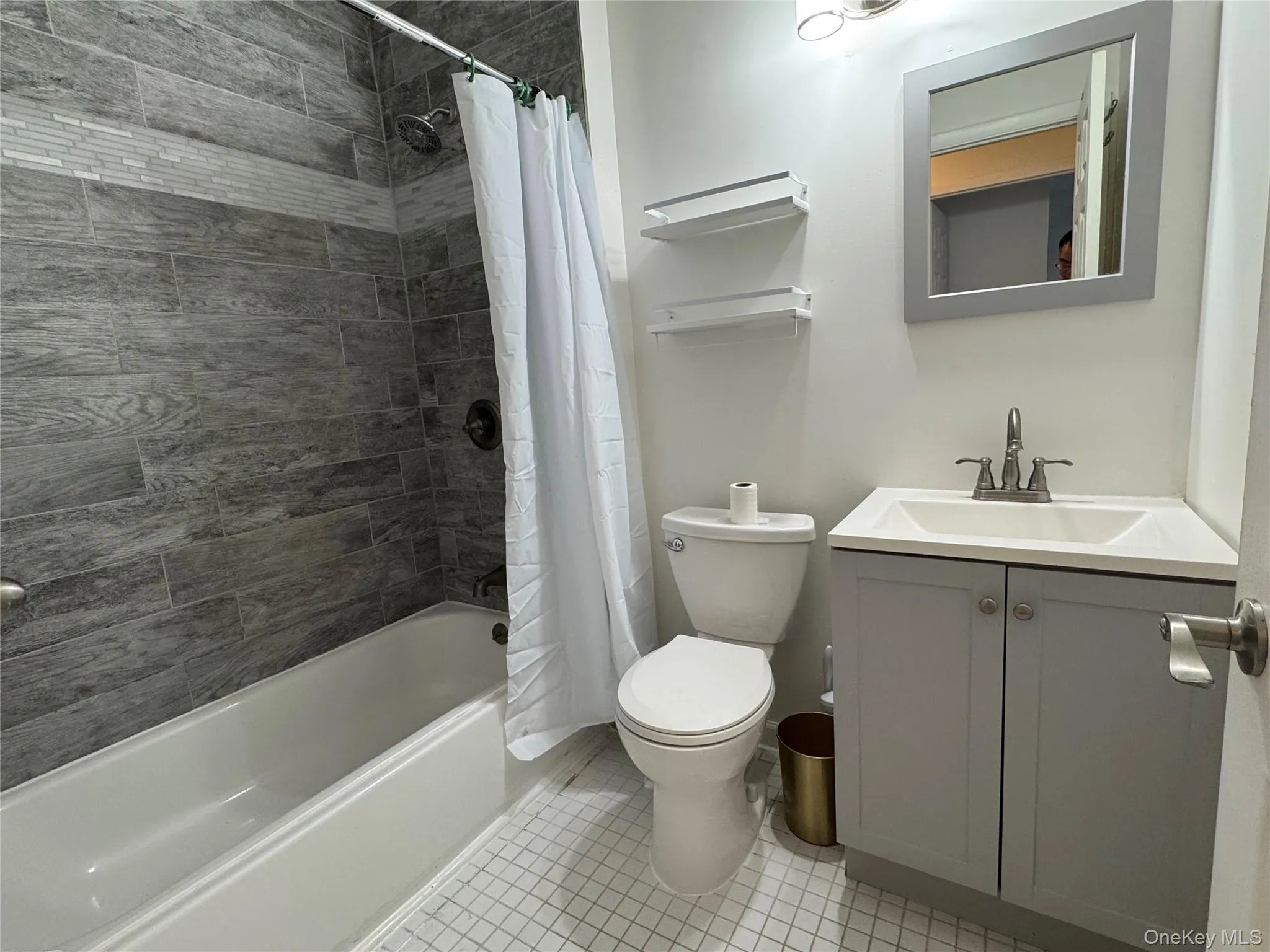 Full bathroom with shower / bath combo with shower curtain, vanity, and light tile patterned flooring Full bathroom with shower / bath combo with shower curtain, vanity, and light tile patterned flooring