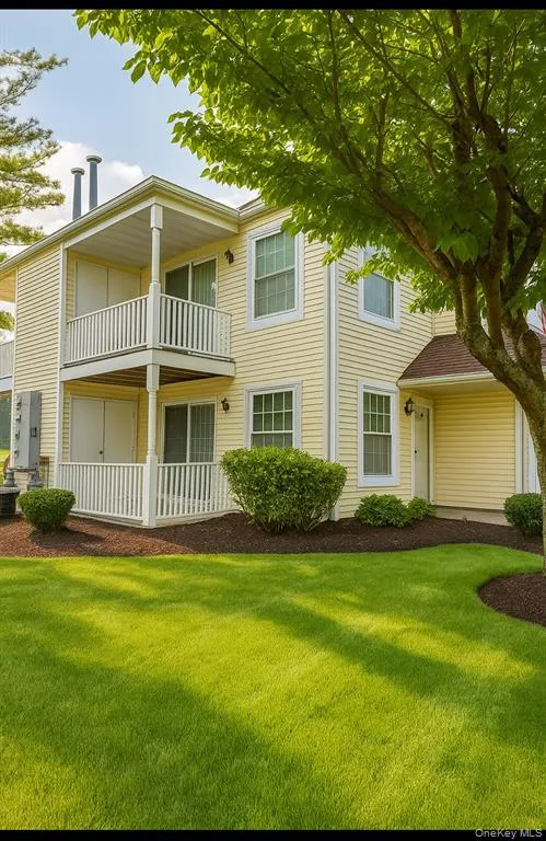 View of front facade featuring a front yard and a balcony View of front facade featuring a front yard and a balcony