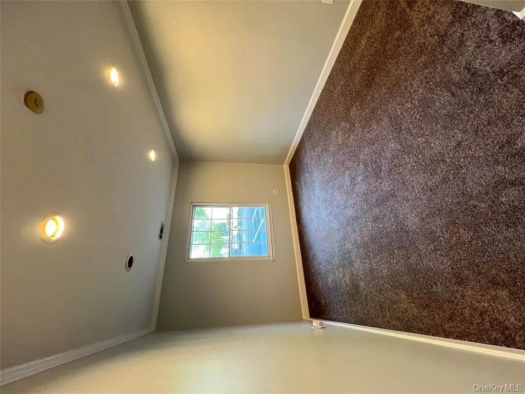 Spare room featuring dark carpet, ornamental molding, and recessed lighting Spare room featuring dark carpet, ornamental molding, and recessed lighting