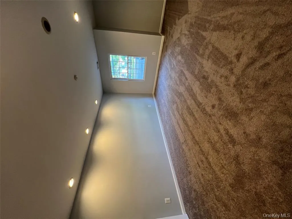 Empty room featuring dark colored carpet and recessed lighting Empty room featuring dark colored carpet and recessed lighting
