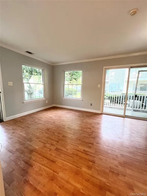 Spare room with crown molding and light wood finished floors Spare room with crown molding and light wood finished floors