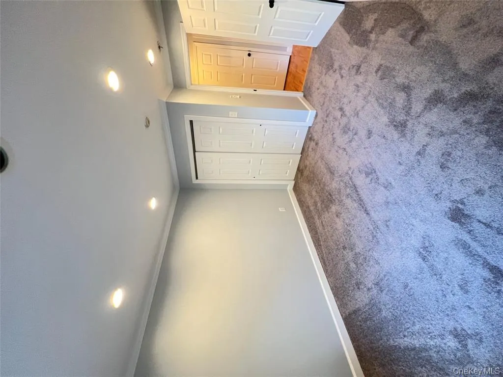 Unfurnished bedroom with crown molding, dark carpet, recessed lighting, and a closet Unfurnished bedroom with crown molding, dark carpet, recessed lighting, and a closet