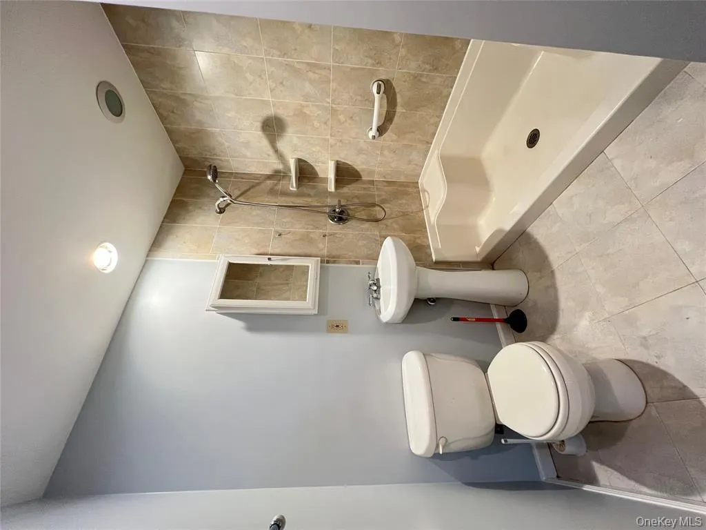 Full bath with tiled shower, light tile patterned flooring, and recessed lighting Full bath with tiled shower, light tile patterned flooring, and recessed lighting