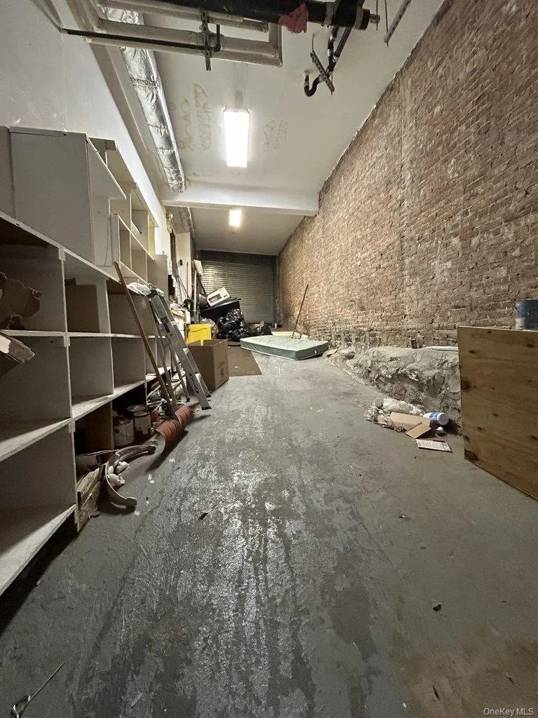 Miscellaneous room featuring brick wall and a garage Miscellaneous room featuring brick wall and a garage