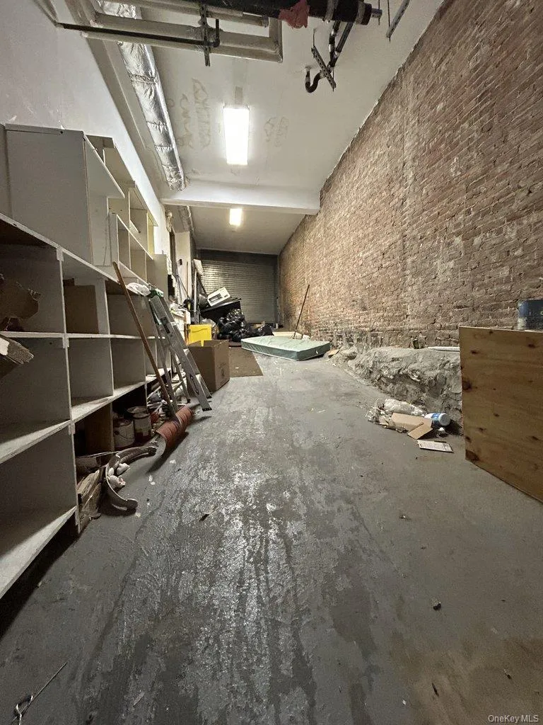 Miscellaneous room featuring brick wall and a garage Miscellaneous room featuring brick wall and a garage