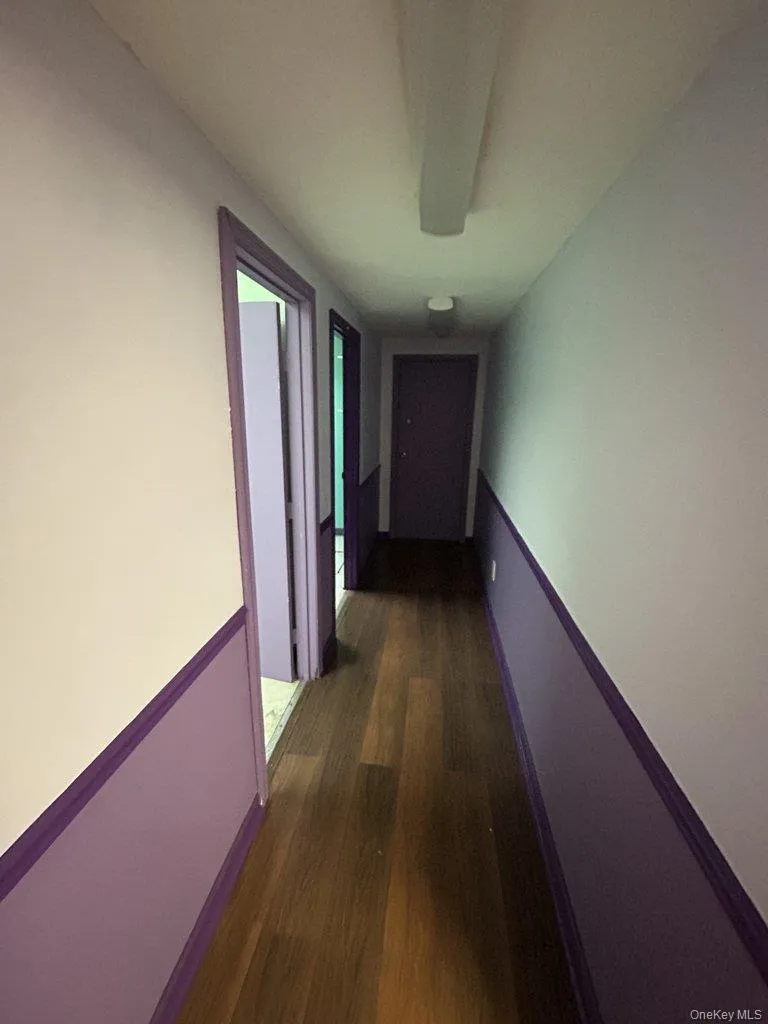 Hallway featuring dark wood-style flooring Hallway featuring dark wood-style flooring