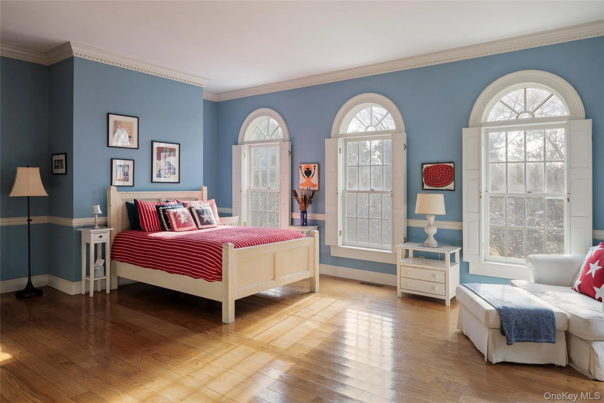 Bedroom featuring multiple windows, baseboards, crown molding, and wood-type flooring Bedroom featuring multiple windows, baseboards, crown molding, and wood-type flooring