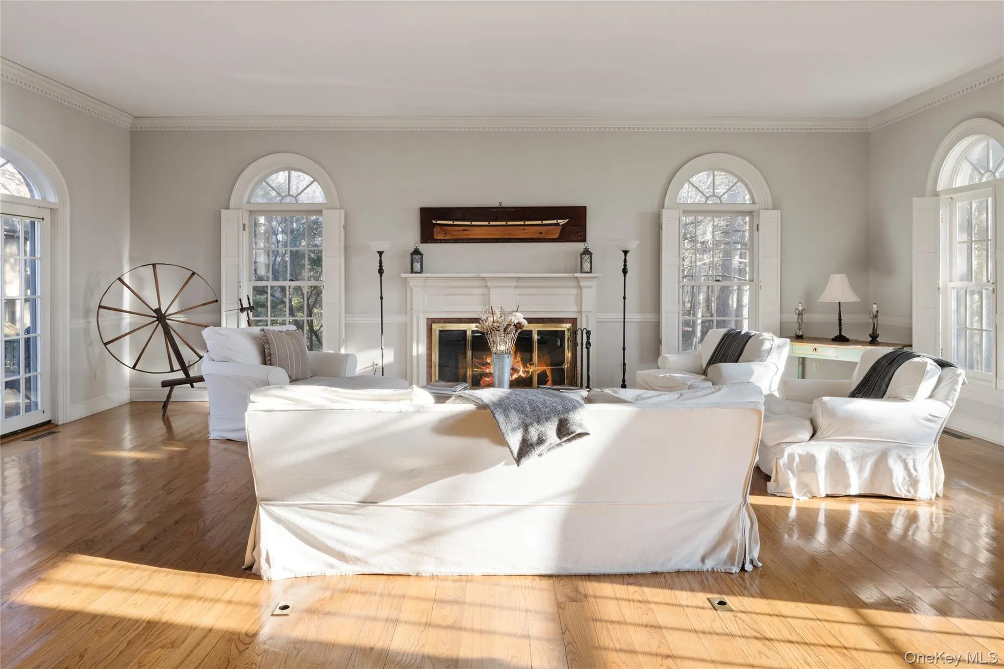 Living room with ornamental molding, a healthy amount of sunlight, and wood finished floors Living room with ornamental molding, a healthy amount of sunlight, and wood finished floors