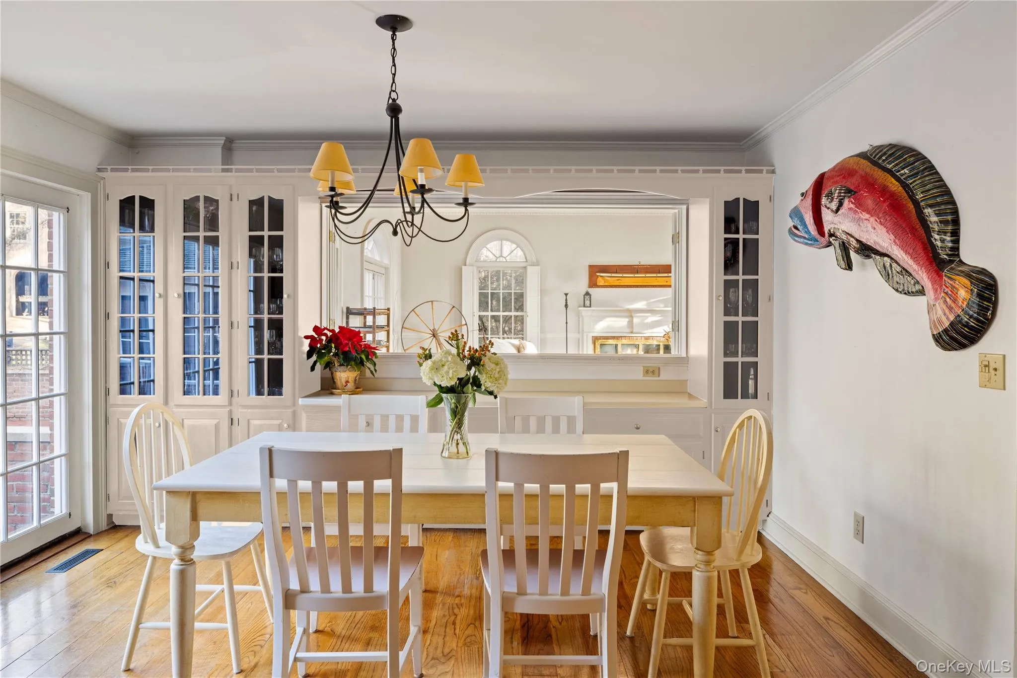 Dining space featuring visible vents, ornamental molding, baseboards, light wood-style flooring, and a notable chandelier Dining space featuring visible vents, ornamental molding, baseboards, light wood-style flooring, and a notable chandelier
